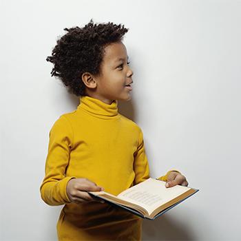 petit garçon livre ouvert et debout