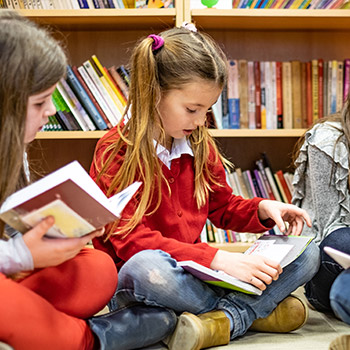 enfants lisant des livre dans une bibliothèque