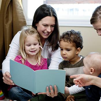femme avec enfants lisant un livre