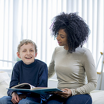 femme avec un enfant handicapé et un livre