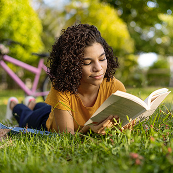 jeunne femme allongée sur de l'herbe lisan tun livre